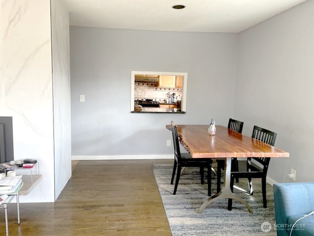 dining space featuring wood finished floors and baseboards