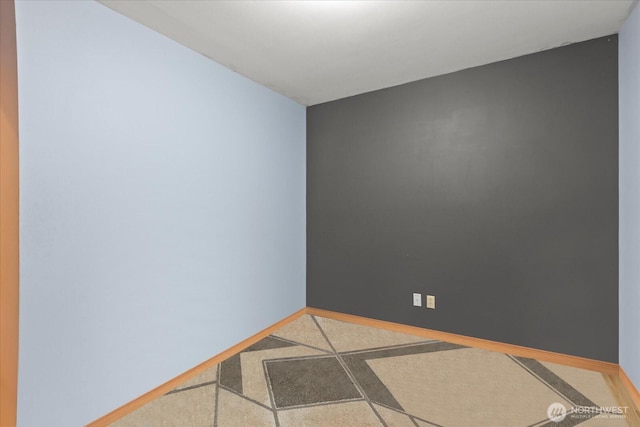 empty room with speckled floor and baseboards