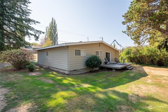 back of house featuring a deck and a lawn