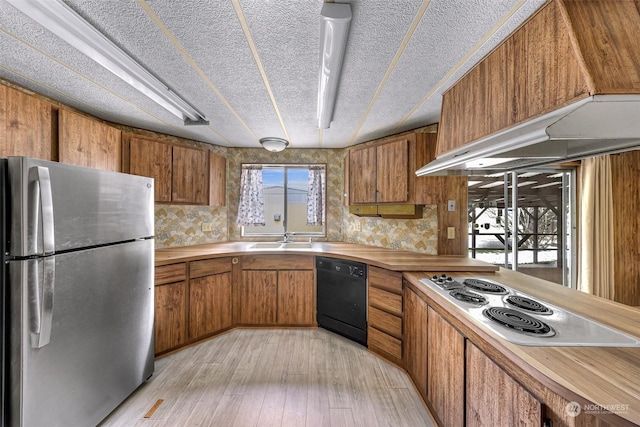 kitchen with sink, white electric stovetop, stainless steel refrigerator, black dishwasher, and light hardwood / wood-style floors