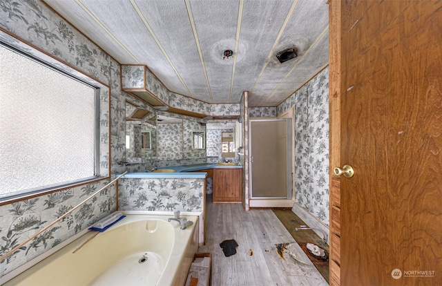 bathroom with wood-type flooring, separate shower and tub, a textured ceiling, and vanity