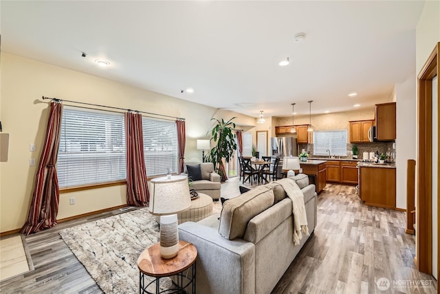 living area with light wood finished floors, baseboards, and recessed lighting