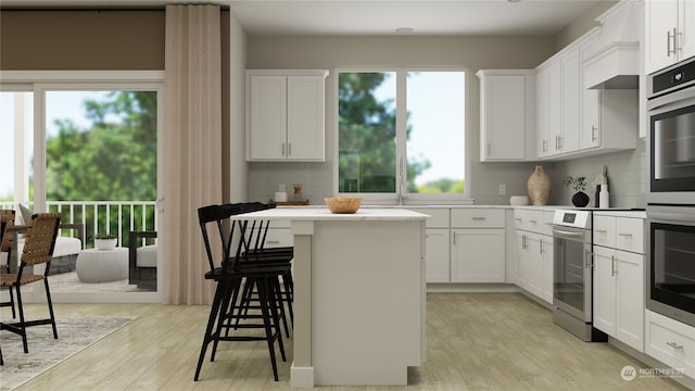 kitchen with a breakfast bar area, stainless steel appliances, a center island, white cabinets, and custom exhaust hood