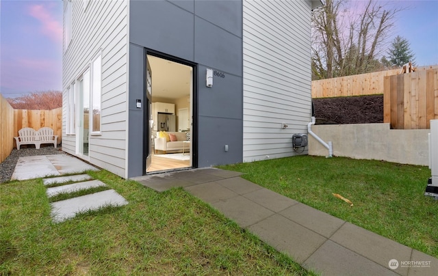 property exterior at dusk featuring a yard