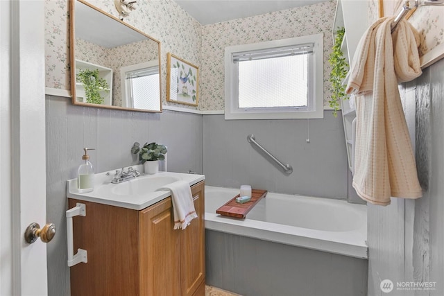 bathroom featuring vanity and a washtub