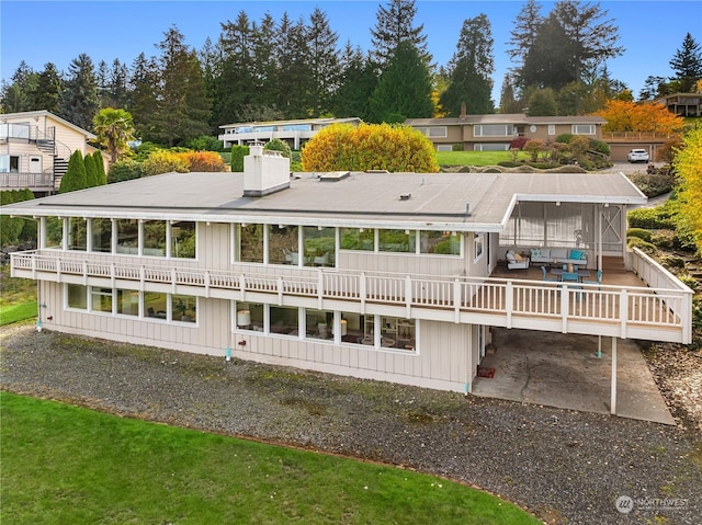 rear view of property featuring a deck and a patio area