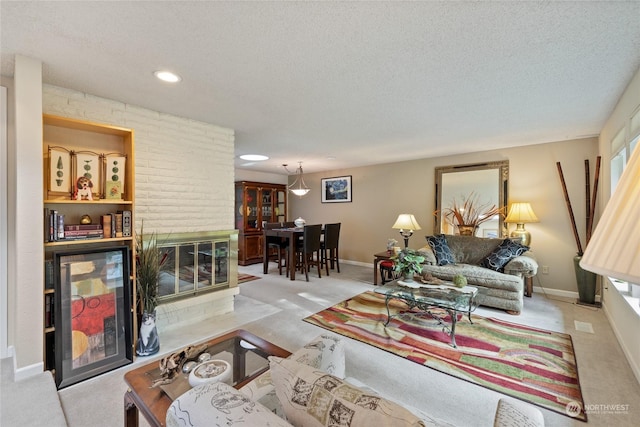 living room featuring a brick fireplace and a textured ceiling