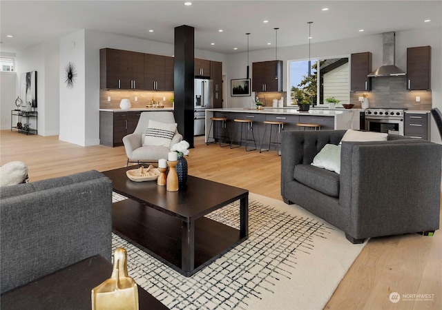 living room featuring sink and light hardwood / wood-style flooring