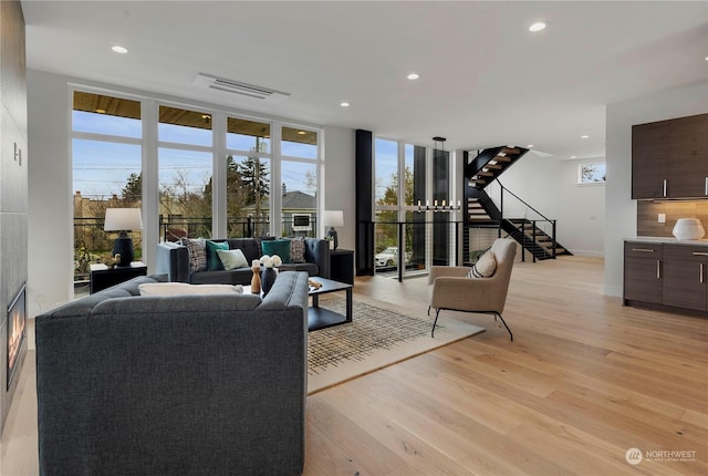 living room featuring floor to ceiling windows and light wood-type flooring