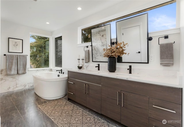 bathroom with vanity and a bath