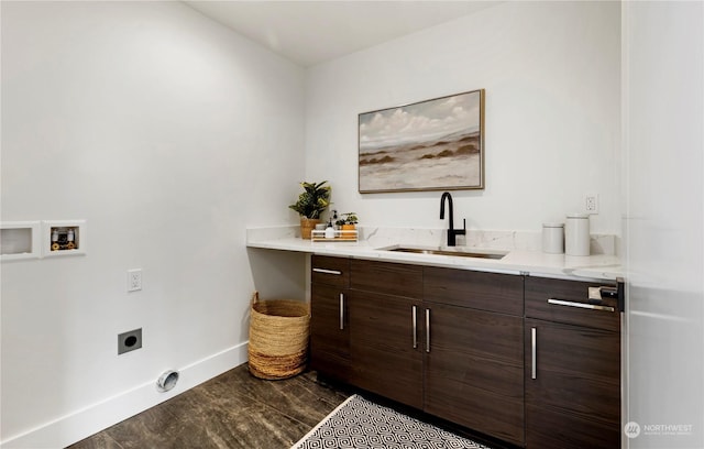 clothes washing area with sink, dark hardwood / wood-style flooring, cabinets, washer hookup, and hookup for an electric dryer