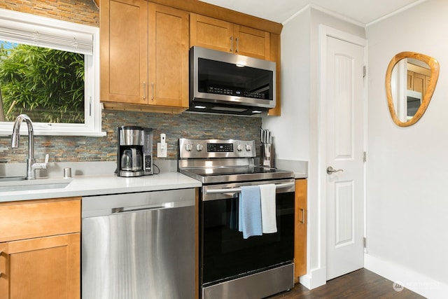 kitchen featuring tasteful backsplash, appliances with stainless steel finishes, dark wood-type flooring, and sink