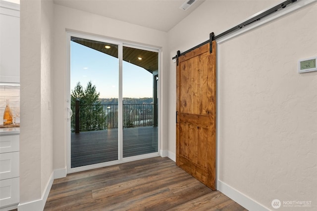 entryway with dark wood-type flooring and a barn door