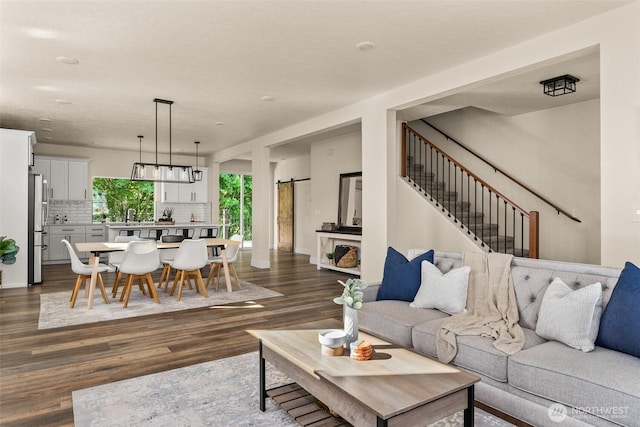 living room featuring dark hardwood / wood-style flooring, a barn door, and sink