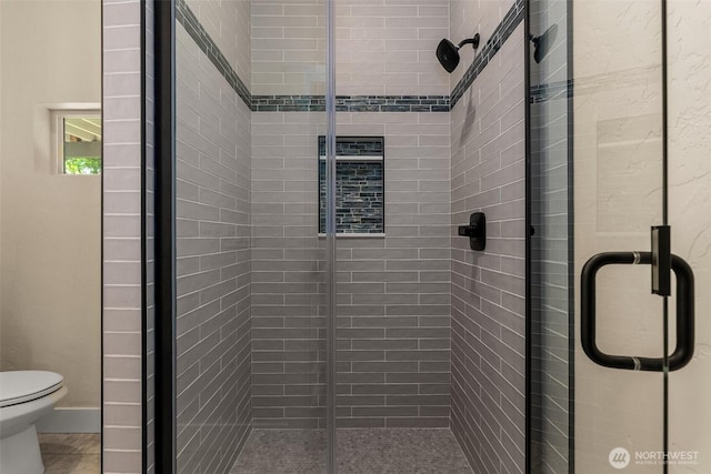 bathroom featuring tile patterned flooring, toilet, and walk in shower