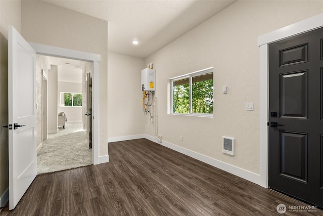 foyer entrance with dark wood-type flooring and water heater