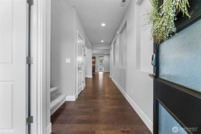 hall featuring stairway, dark wood-style floors, visible vents, baseboards, and recessed lighting