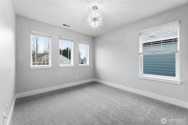 empty room featuring baseboards, visible vents, carpet floors, and an inviting chandelier