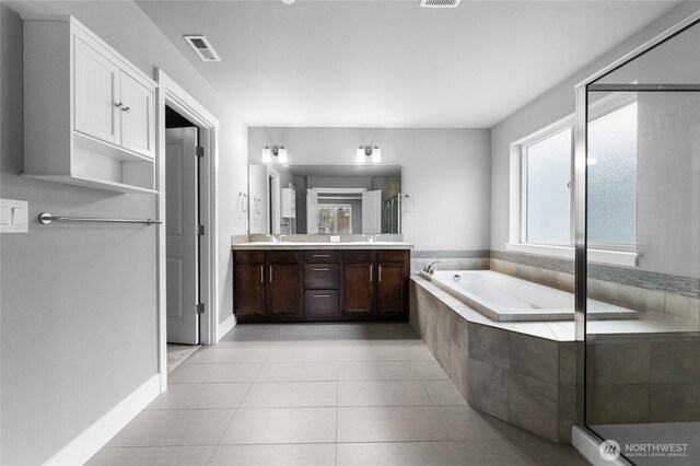 bathroom with tile patterned flooring, double vanity, a bath, and a shower stall