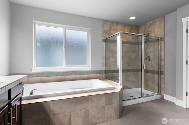 full bathroom with vanity, a shower stall, a garden tub, and tile patterned flooring