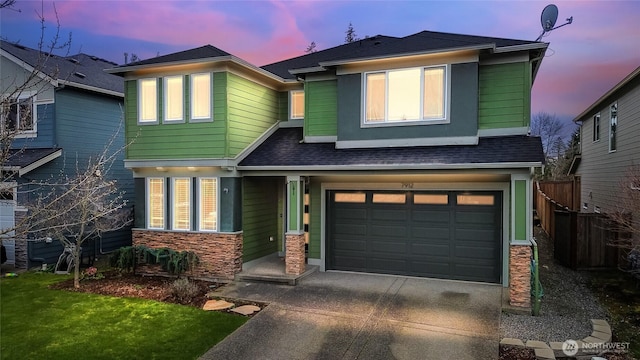 view of front of home with fence, roof with shingles, a garage, stone siding, and driveway