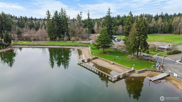 drone / aerial view with a forest view and a water view