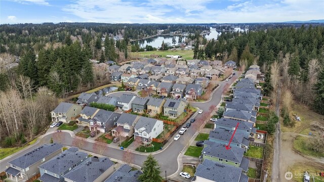 aerial view with a residential view, a forest view, and a water view