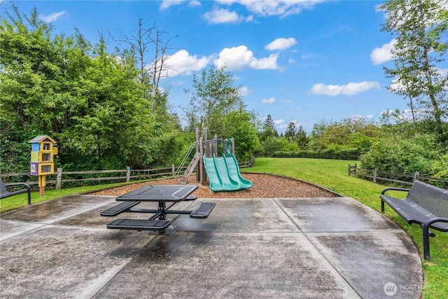 community playground featuring a lawn and fence