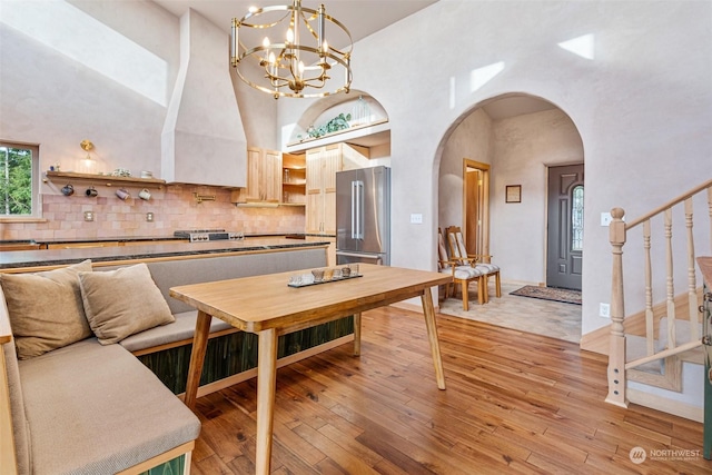 dining space with a high ceiling and light wood-type flooring