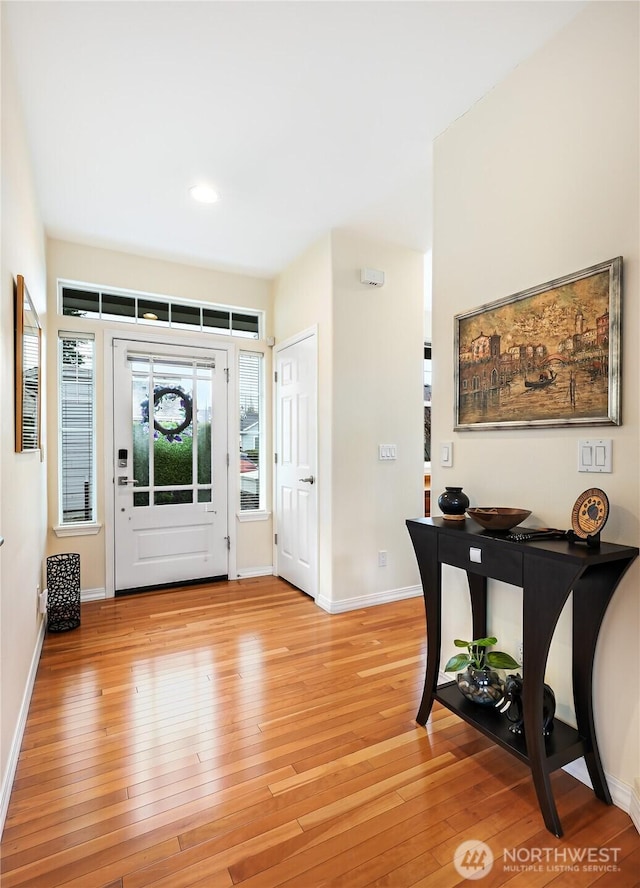 foyer with light wood finished floors and baseboards