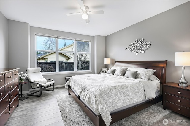 bedroom featuring baseboards, wood finished floors, and a ceiling fan