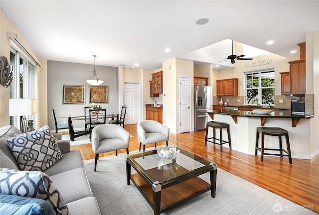 living area with recessed lighting, light wood finished floors, and ceiling fan