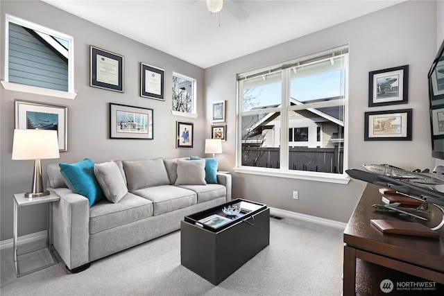 carpeted living room featuring ceiling fan and baseboards