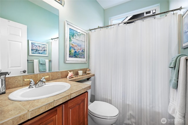 bathroom featuring a shower with curtain, toilet, and vanity