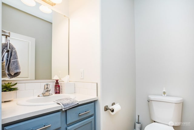 bathroom featuring tasteful backsplash, vanity, and toilet