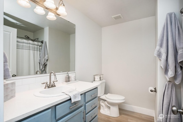 bathroom featuring hardwood / wood-style flooring, vanity, toilet, and a chandelier