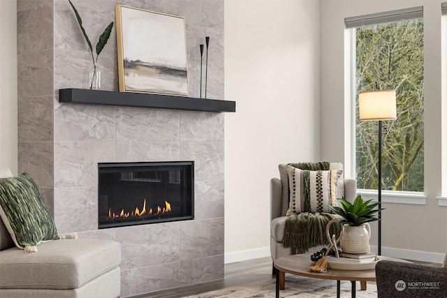 living area with hardwood / wood-style flooring, plenty of natural light, and a fireplace