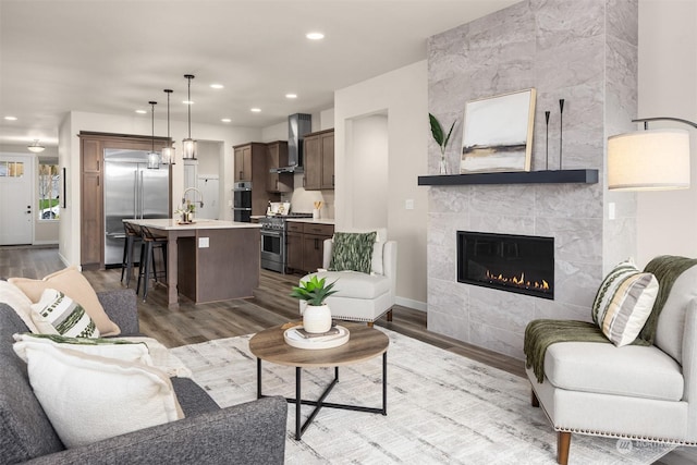 living room featuring sink, a fireplace, and light hardwood / wood-style floors