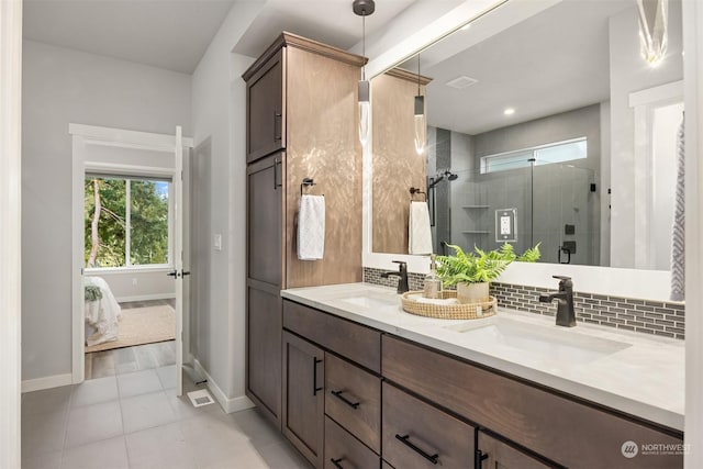 bathroom with an enclosed shower, backsplash, vanity, and tile patterned flooring