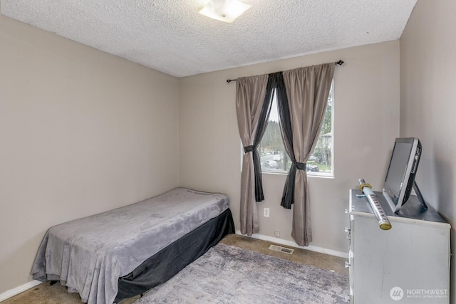 bedroom with carpet floors and a textured ceiling