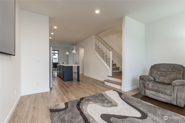 living room with sink and light hardwood / wood-style floors