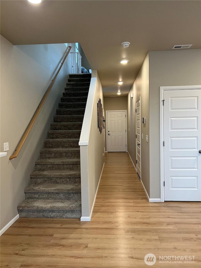 staircase with hardwood / wood-style flooring