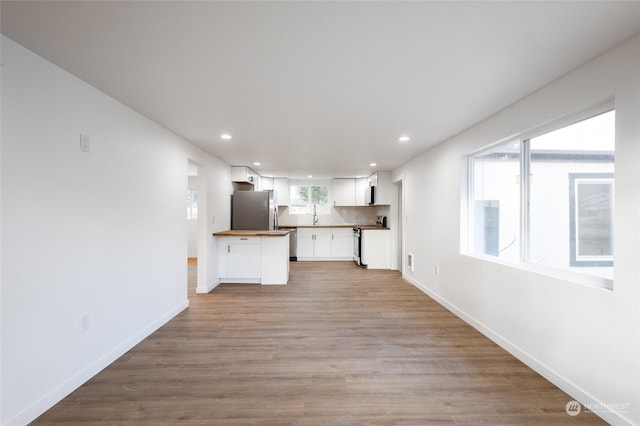 unfurnished living room with sink and light wood-type flooring