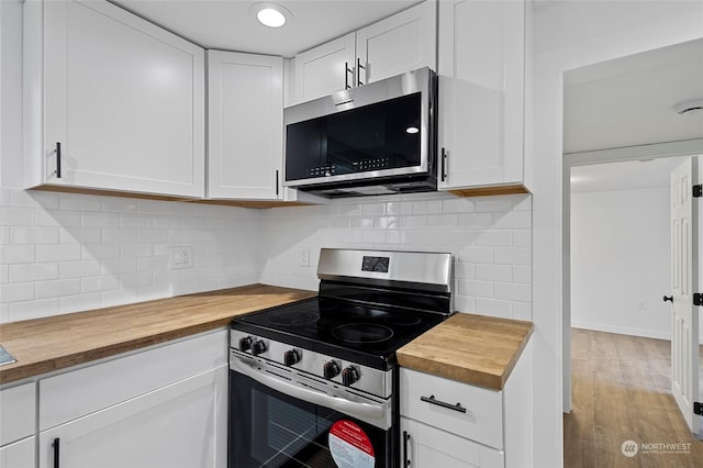 kitchen featuring white cabinetry, wood counters, appliances with stainless steel finishes, and tasteful backsplash