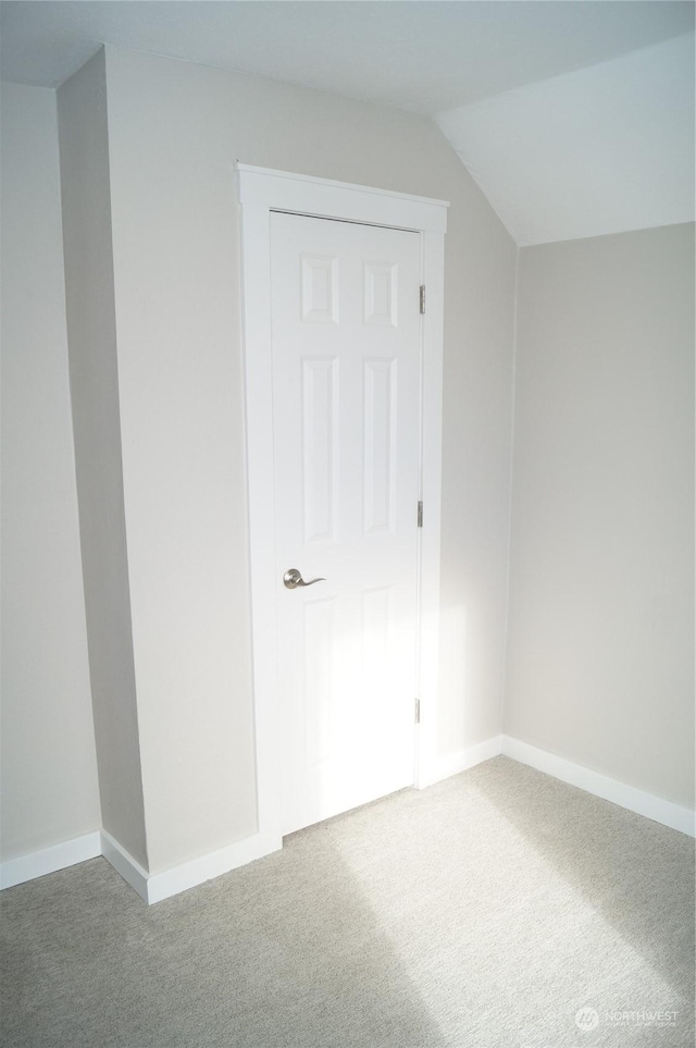 bonus room with vaulted ceiling and carpet