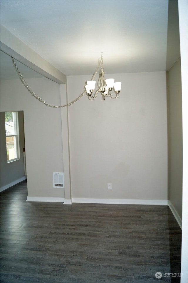 unfurnished room with an inviting chandelier and dark hardwood / wood-style floors