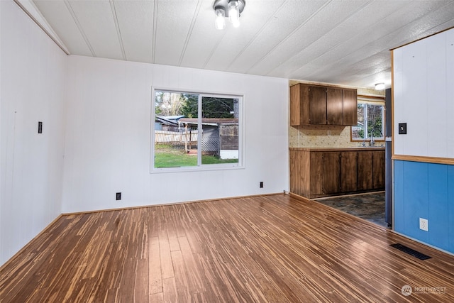 unfurnished living room with dark hardwood / wood-style flooring and sink