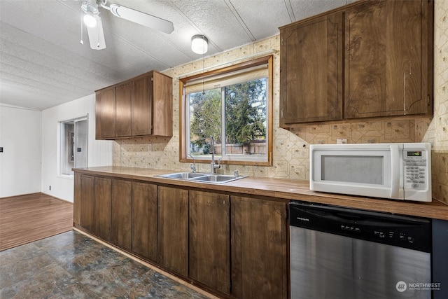 kitchen featuring sink, backsplash, stainless steel dishwasher, and ceiling fan