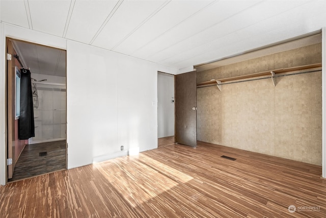 unfurnished bedroom with wood-type flooring and a closet