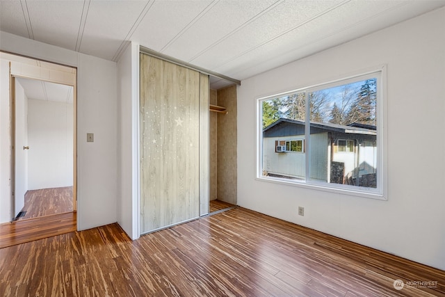 unfurnished bedroom with hardwood / wood-style floors and a closet